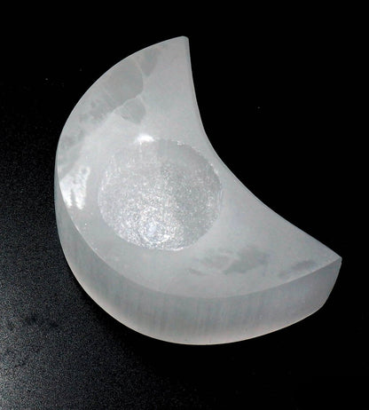 Selenite Moon Tealight on a black background.
