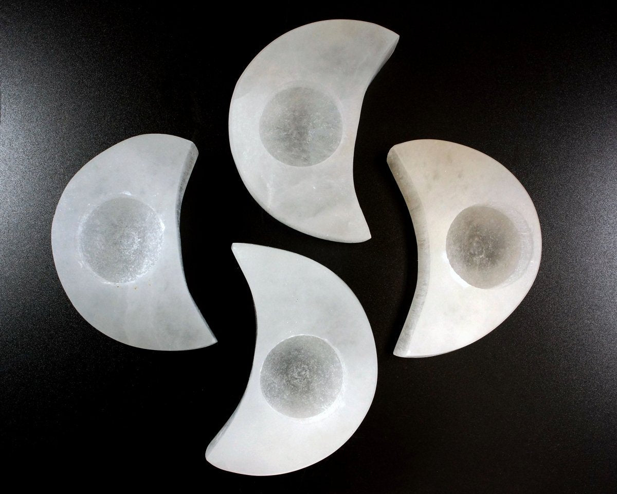 Four Selenite Moon Tealight on a black background.